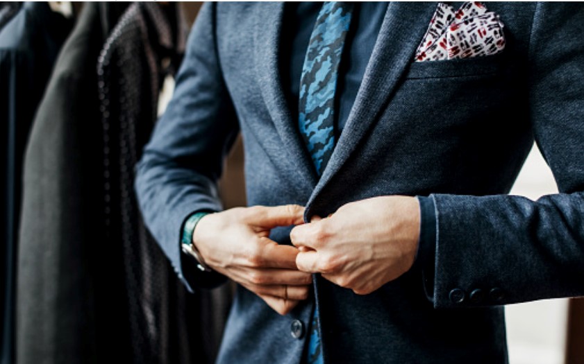 A man is  wearing a custom bespoke suit